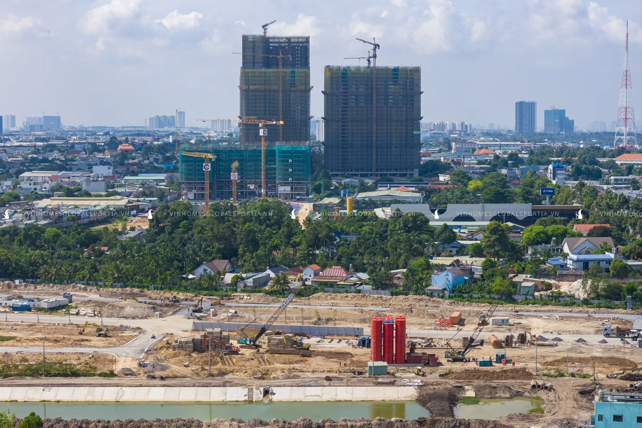 Công trình đang thi công với cần cẩu và trụ bê tông, phản ánh tiến độ bàn giao dự án bất động sản